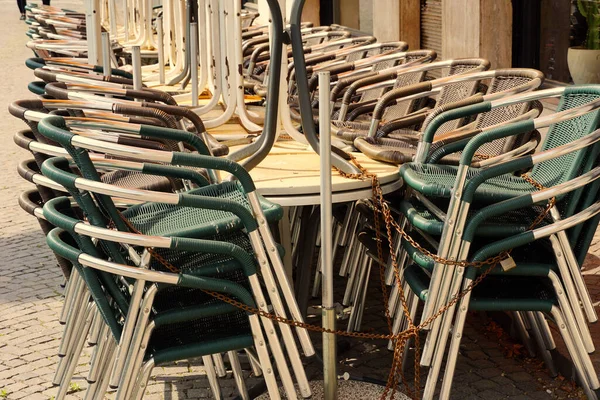 Mesas y sillas de un restaurante pegadas y encadenadas. Últimos días de estancia en casa en Merano, Italia . — Foto de Stock