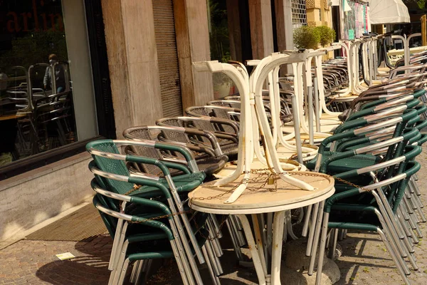 Stoly a židle restaurace přilepené a svázané řetězy. Poslední dny pobytu na domácí objednávku v Merano, Itálie. — Stock fotografie