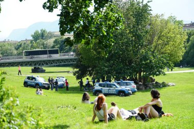 Polis, ağacın altında toplanan insanları kontrol ediyor..