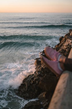 Denizin üzerinde asılı pembe ayakkabılar.