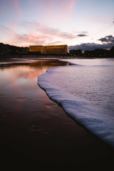 Foamy mar de la playa de Zurriola en San Sebastián después del atardecer. — Foto de Stock