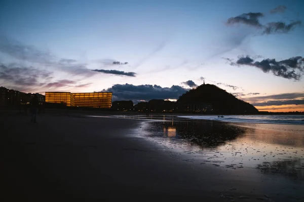 Gün batımından sonra aydınlanan bina ve Urgull Dağı San Sebastian 'daki deniz kıyısına yansıdı.