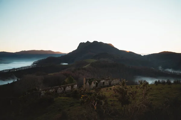 Ruinas de un antiguo castillo y una icónica montaña del País Vasco al atardecer — Foto de Stock