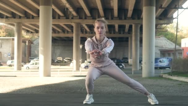 Mladá Krásná Dívka Sportovním Oblečení Kapucí Sluchátkách Dělá Strečink Cvičení — Stock video