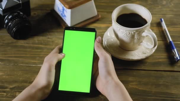 Menina Está Sentada Casa Mesa Segurando Smartphone Com Tela Verde — Vídeo de Stock