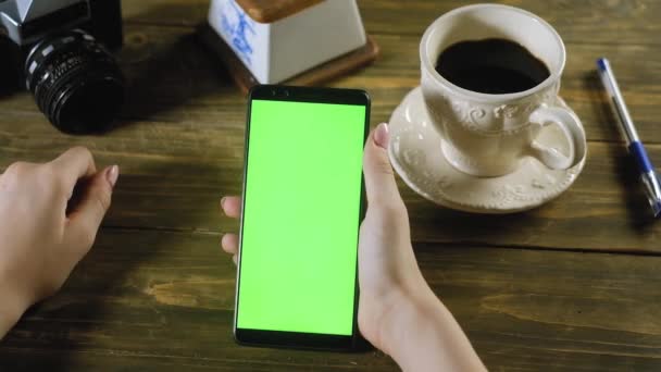 Menina Está Sentado Mesa Madeira Segurando Smartphone Com Tela Verde — Vídeo de Stock