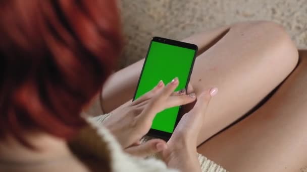 女性在网上使用绿色屏幕 一个成年女孩拿着一个有绿色屏风的现代手机 智能手机上的Chromakey 使用绿色布局插入图像 手和手指的姿势 靠近点 — 图库视频影像