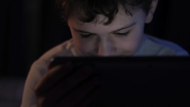 enfant le soir regarder des dessins animés ou des films sur la tablette le soir dans la chambre. Parcourez Internet avant d'aller au lit. Enfance avec une tablette .