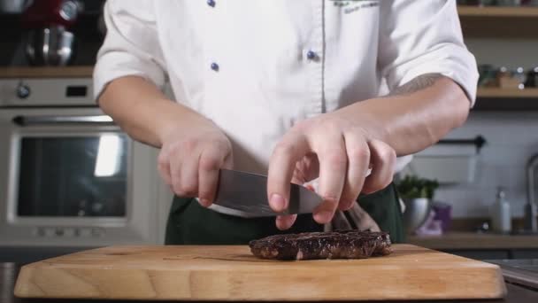 Koch Schneidet Gekochtes Steak Mit Scharfem Messer Auf Holzschneidebrett Stücke — Stockvideo