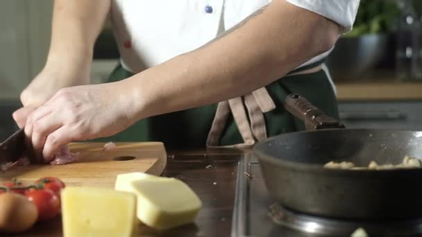 식당의 부엌에서 요리사가 맛있는 요리를 있습니다 요리사는 닭살을 부엌용 잘랐다 — 비디오
