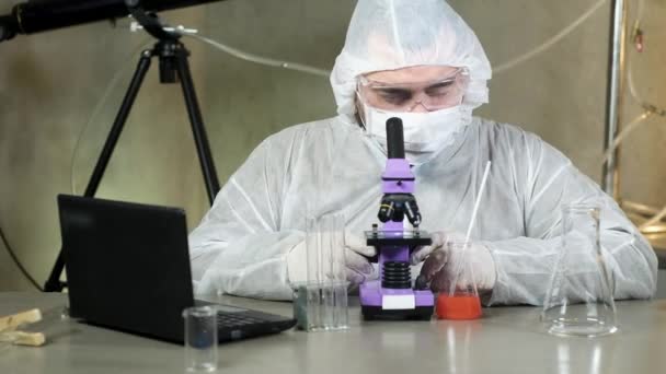 Wissenschaftler Mann Labor Schutzmaske Schaut Ins Mikroskop Und Druckt Daten — Stockvideo
