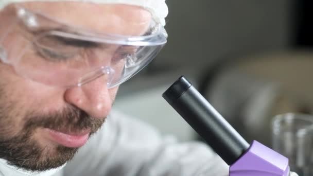 실험실의 과학자들은 현미경을 통하여 확대경을 변화시키고 미생물학이나 약리학 에서의 과학적 — 비디오