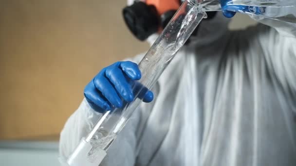 现代实验室呼吸器中的科学家生物化学家将清澈的溶液从试管倒入烧杯 化学科学实验 药物研发概念 — 图库视频影像