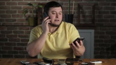 Ofisteki erkek yönetici müşterilerle telefonda konuşuyordu. Masada bir sürü telefon var ve çalıyor. Telefona cevap veren kişi. İş yerinde iş yükü