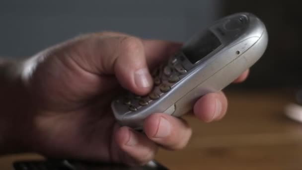傷を負った時代遅れの携帯電話のキーボードで電話番号をタップした男の手のクローズアップ 古い携帯電話のキーボード上のボタンのマクロ撮影 現代の無線技術 — ストック動画