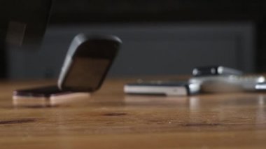 Eski çizik eski cep telefonları ofis masasına düşer ve kırılır ve farklı yönlere uçar. Ofiste analog iletişim. Modern kablosuz teknoloji. Retro elektroniğin geri dönüşümü.