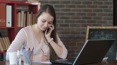 Avrupalı bir kız ofiste ya da evde çalışır. Müdür büyük bir müşteriyle telefonda konuşur ve müşteri bilgilerini bir not defterine yazar..