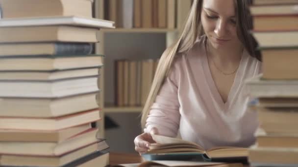 Mädchen Sitzt Tisch Der Bibliothek Zwischen Vielen Büchern Und Lehrbüchern — Stockvideo