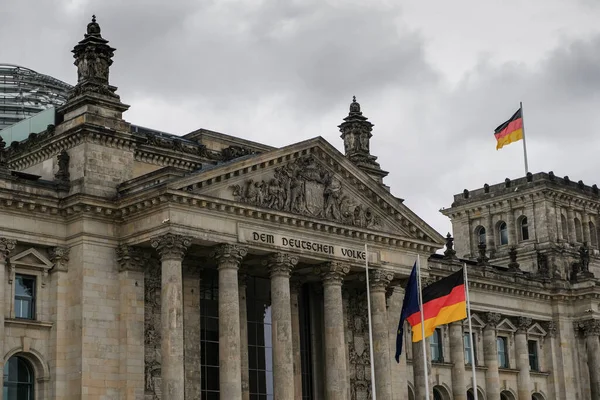 Berlin famous historic reichstag facade with german flags over cloudy sky,symbol — Stock Photo, Image