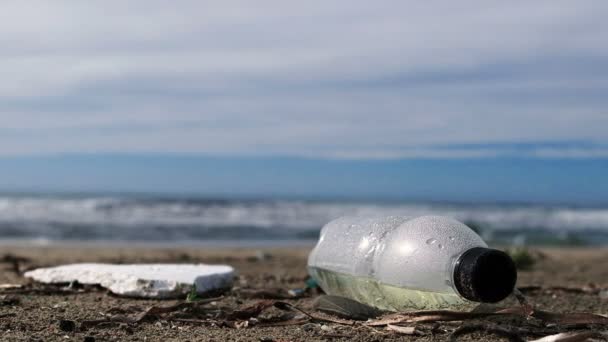 Bottiglia di plastica spazzatura sull'ecosistema marino su onde sfocate movimento sfondo, 4k — Video Stock