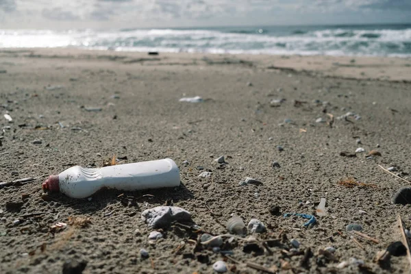 冬季海岸上的塑料容器背景模糊，星球污染 — 图库照片