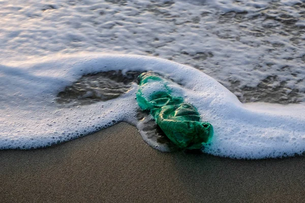 Botella de plástico verde en espuma de agua de mar del océano, concepto libre de contaminación del ecosistema —  Fotos de Stock