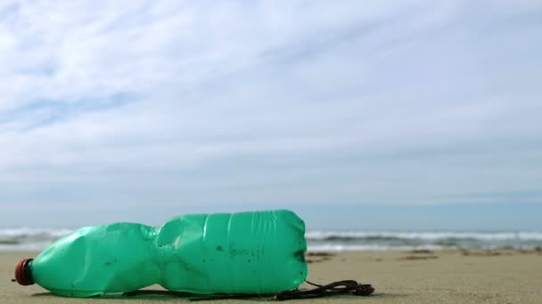 Zoom para fora vista de garrafa de plástico verde no ecossistema do mar sobre o fundo ondas, 4k — Vídeo de Stock