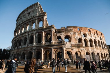 İnsanlarla eski kolezyum cephesinin klasik renkli görüntüsü, Roma şehir harikalarının keyfini çıkar.
