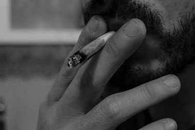 Young man smoking cannabis marijuana,black and white addiction concept 