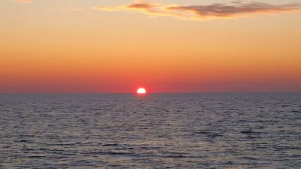 Céu vermelho inspirador do por do sol com ondas do mar que salpicam o movimento, sol vai para baixo italy — Vídeo de Stock