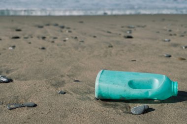 Vahşi deniz kıyısındaki plastik sabun kabı kirlenmiş ekosistem, endüstriyel çöp