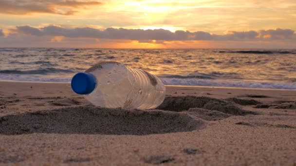 Poubelle bouteille en plastique sur le rivage sablonneux mouvement coucher de soleil, nature polluée, coriandre — Video