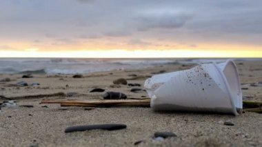 Plastic glass trash on sandy sea shore sunset motion,polluted nature,cilento