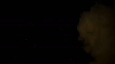 Yıldızlarla, galaksilerle ve kayan yıldızlarla dolu karanlık bulutlu gece göğü hareket ediyor, ışık şeklinde.