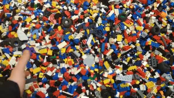 Çocuklar oyuncak eşyalar lego inşaat çok renkli tuğlalar, insan el hareketi — Stok video