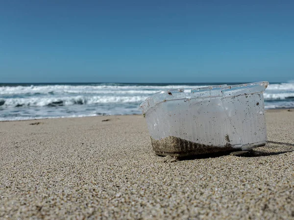 Contêiner plástico poluição na costa do mar arenoso sobre fundo borrão, cilento — Fotografia de Stock