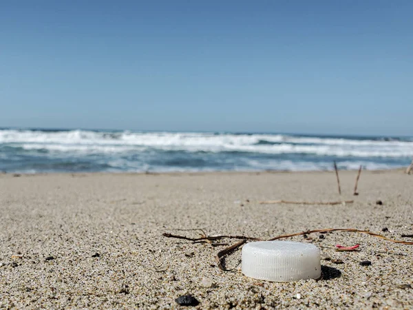 Garrafa de plástico branco cortiça na costa do mar arenoso, ecossistema poluído, microplásticos — Fotografia de Stock