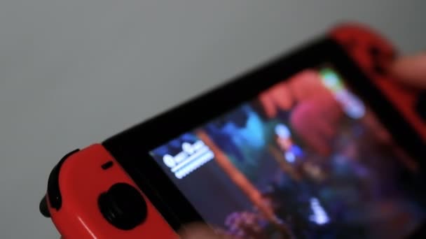 Ung man spelar spel på Nintendo Switch konsol, videospel beroende — Stockvideo