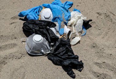Virüs maskesi ve plastik eldivenler deniz kıyısında çöp, koronavirüs covid kirliliği 
