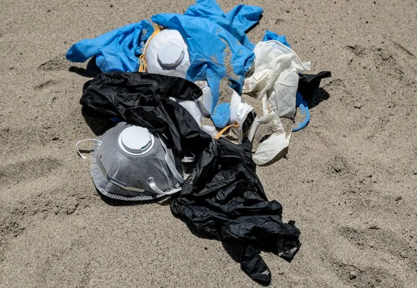 Virus mask and plastic gloves garbage on sea coast,coronavirus covid pollution