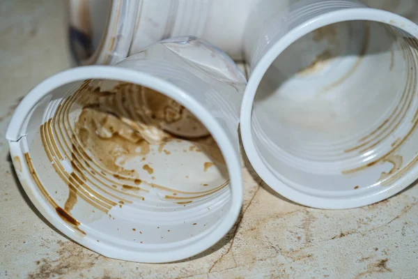 Kirli kahve fincanlarına yakın çekim. Boşaltılan plastik kahve bardakları, kirli tek kullanımlık kirlilik.