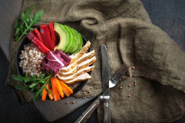 İçinde karabuğday, taze kırmızı ve turuncu biber, avokado ve koyu renkli otlar olan bir kase. Sağlıklı beslenme Süper yiyecek kopyalama alanı üst görünümü.