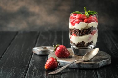 Taze böğürtlenli güzel tatlı. Koyu arkaplanda çikolatalı ve çilekli ıvır zıvır kopyalama alanı.