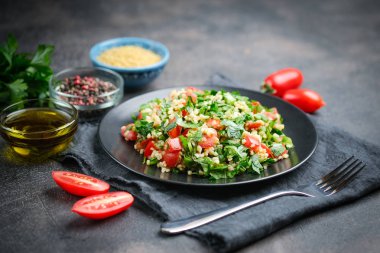 Geleneksel oryantal salata Tabbouleh bulgur ve maydanozlu koyu arkaplan