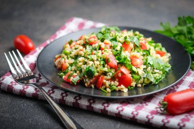 Geleneksel oryantal salata Tabbouleh bulgur ve maydanozlu koyu arkaplan