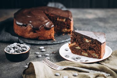 Geleneksel İtalyan çikolatalı keki koyu arkaplanda elmalar ve tarçınlı.