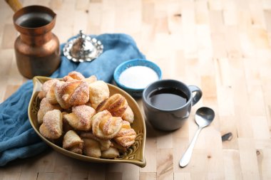 Köy peyniri ve şekerli kurabiyeler, arka planda koyu bir fotokopi alanı üzerinde bir fincan kahveyle..