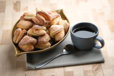 Köy peyniri ve şekerli kurabiyeler, arka planda koyu bir fotokopi alanı üzerinde bir fincan kahveyle..