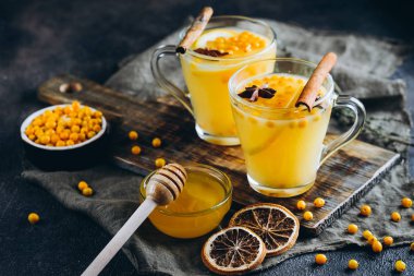 Koyu arkaplanda portakal, tarçın, bal ve baharatlı karabatak çayı.
