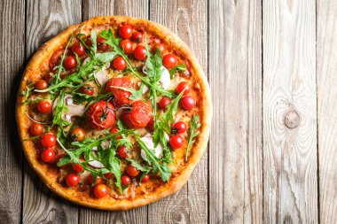 Domatesli, peynirli, jambonlu, mantarlı ve roka arkaplanlı geleneksel İtalyan pizzası..